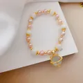 Primo piano del bracciale di perle con occhio di gatto e ciondolo a forma di gatto-pianeta - No. 5 Gatto