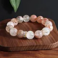Detailansicht eines Super Seven Kristallarmbands mit natürlichen Rutilquarzsteinen - Transfer-Ring / 12mm