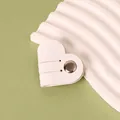 White heart-shaped PU leather cable organizer with a silver metal snap button closure - White