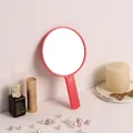 Pink handheld round makeup mirror for daily beauty routine in a stylish decorative setting - Round Mirror / Red