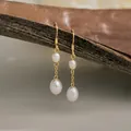 Primer plano de pendientes de oro de 14K con dos perlas barrocas naturales brillantes - Pendientes de perlas de agua dulce