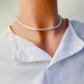Gros plan d'un collier chaîne serpent plate argentée sur un col de chemise blanc - Large Silver Herringbone Chain / Argent