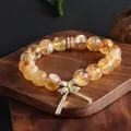 Detailed view of a natural yellow crystal bracelet with a sparkling butterfly bow charm. - Yellow Crystal Style / Yellow Crystal Gold Bow