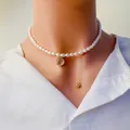 Gros plan détaillé du collier de perles d'eau douce avec pendentif de cerf doré et gland - Deer Zirconia Round Plaque / Or