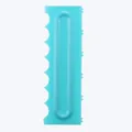 Detail view of a turquoise plastic cake scraper with serrated edges for baking designs - Semi-Circular Large Style (84004-23)
