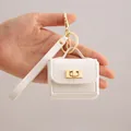Mini white PU leather bag keychain with golden lock for portable earphone storage - White