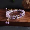 Macro view of a double-strand natural amethyst beaded bracelet with elegant gold tassels - Amethyst Style