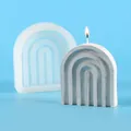 Detailed view of a U-shaped rainbow arch silicone mold alongside a finished burning candle - Arch Rainbow Bridge (50-2852-D) / White