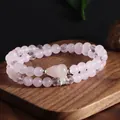 Gros plan d'un élégant bracelet double rang en quartz rose avec accents en cristal sur bois - Style Gourde