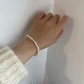 Elegant baroque freshwater pearl bracelet on wrist styled with a cream knit sweater - Baroque Freshwater Pearl Bracelet / Single Piece / White