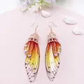 Detailansicht eleganter Ohrhänger mit Schmetterlingsflügel-Gradient und funkelnden Strasssteinen - Roségold - Oranger Strass
