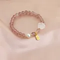 Macro view of strawberry quartz bracelet with pearl, cat paw and golden blessing charm - Cat Claw and Fu Charm Style