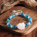 Detailaufnahme eines Armbands mit blauen Achatperlen und einer geschnitzten Katze. - Fuchs-Stil