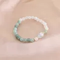 Detaillierte Makroansicht eines Perlenarmbands aus grünem Achat und rosa Kristall auf Satin - Hellgrün Weiß Ovaler Risskristall Stil