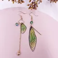 Elegante asymmetrische Ohrringe mit grünen Zikadenflügeln und goldenen Quasten - Grün Gold