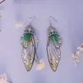 Detailansicht der langen Zikadenflügel-Ohrringe mit grünem Verlauf und Strass - Farbverlauf Grün-Silber-Strass