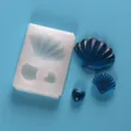 Dettaglio dello stampo in silicone a conchiglia e cuore con pezzi in resina glitterata blu - Stile Combinato Conchiglia e Cuore / Bianco