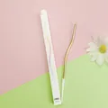 Detail of a single gold curved birthday cake candle with its white slim cardboard packaging box - 1 Piece / Champagne Gold