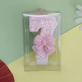 Primer plano de una vela de cumpleaños rosa brillante número 7 con un gran lazo decorativo - Vela de Número Lazo Rosa 7