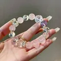 Nahaufnahme eines Naturkristallarmbands mit geschnitzten Rosen- und Bärenperlen in Rosa - Pink White Purple Mixed Bracelet / bunt