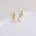 Dettaglio orecchini a perno a nodo dorato con perle d'acqua dolce bianche naturali - Stile Annodato / Design Annodato Oro