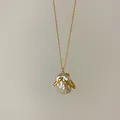 Dettaglio collana con pendente in perla barocca retrò e design a mani che abbracciano. - Collana d'oro