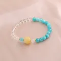 Detailansicht eines Naturkristallarmbands mit türkisfarbenen Perlen und Kürbisanhänger. - Hellgelbe Kürbisperle Seeblau Achat Stil