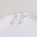 Primo piano dettagliato di orecchini a nodo argento con perle bianche naturali pendenti. - Stile Annodato / Design Annodato Argento