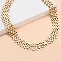 Detail of a wide gold punk style watch-band link necklace on a display block - Gold