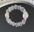 Nahaufnahme eines Naturkristallarmbands mit klaren und lila Perlen und Rose - Weißes und lila Fucharmband / Violett Weiß