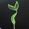 Macro view of a green glitter mermaid tail cake topper with elegant cutouts on stick. - Green / 1 Piece
