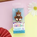 Detail van een bruine teddybeer verjaardagskaars met feesthoedje en strikje in verpakking - Rood Groene Feestmuts Beer / 1 Stuk
