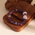 Macro detail of purple amethyst beaded bracelet with pink crystal fox charm. - Amethyst With Accessories