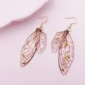 Detailed macro shot of vintage cicada wing earrings featuring embedded gold foil flakes. - Gold Leaf Design / Gray