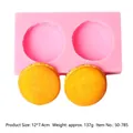 Gedetailleerd overzicht van roze 3D-macaron siliconen mal met twee gele afgewerkte modellen - 2-Gats Roze Macaron Vorm (50-785-A)
