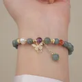 Detalle de una pulsera de cuentas de jade y cristal con un colgante de mariposa. - Colgante de Mariposa con Diamantes de Imitación / Gris Azulado
