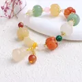 Detailansicht eines ethnischen Jade-Armbands mit geschnitzten Kürbis- und hulu-Anhängern - Bunte Kürbisperlen Bambusgelenke Hängender Kürbis
