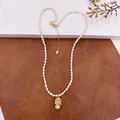 Detailed view of a vintage natural baroque pearl necklace with a gold Buddha pendant. - Little Buddha Pendant Necklace / Gold Buddha White Pearl