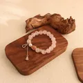 Detailansicht eines rosa Kristallperlenarmbands mit goldenem Flaschenkürbis-Anhänger. - Rosa Kristall Flaschenkürbis Armband / Rosa