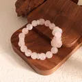 Macro view of pink rose quartz beads and white agate with a carved nine-tailed fox charm - Pink Quartz With Accessories
