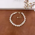 Close-up of elegant natural baroque pearl necklace with gold clasp on leather background - Pearl Bracelet