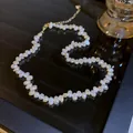 Close-up of irregular freshwater pearl necklace on reflective black surface - Necklace / Beige