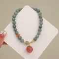 Vista detallada de una pulsera de cuentas de jade con un dije de cristal de fresa - Colgante de Melocotón Yanyuan / Gris Azulado