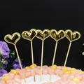 Vista detallada de cinco adornos para pasteles con forma de corazón dorado en postre - Corazón Dorado (5 Piezas)