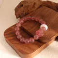 Detailed view of pink strawberry quartz beaded bracelet with carved nine-tailed fox charm - Strawberry Quartz