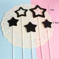 Vue détaillée des décorations de gâteau étoiles noires en tailles 3,5 cm et 6 cm - Pack de 5 / Noir