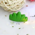 Vue détaillée d'un ornement d'herbe en résine verte, dimensions 3,7 cm x 2,1 cm - 3,7 cm x 2,1 cm