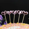 Primer plano de cinco adornos para tarta con forma de corazón rosa metálico en un pastel. - Corazón Rosado (5 Piezas)