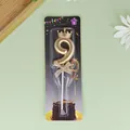 Vela de cumpleaños número 9 dorada con decoración de corona sobre fondo verde claro - Corona Número 9 / Champán