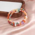 Detail of double-layer beaded gemstone bracelet with amethyst on pink satin background - Double Loop Style / Dark Mixed Golden Silk Jade